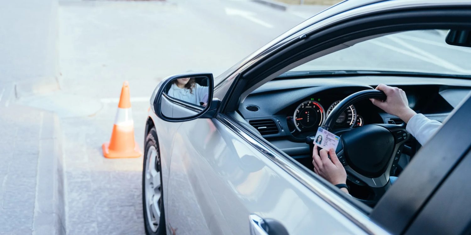 Študent v aute autoškoly s vodičským preukazom